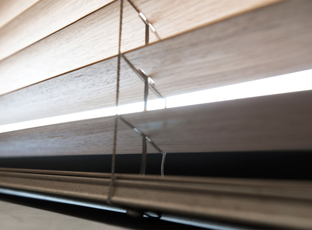 Decorquip light wood Venetian blind with horizontal slats partially open
