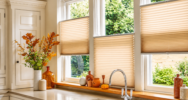 Decorquip beige pleated blinds partially covering tall kitchen windows