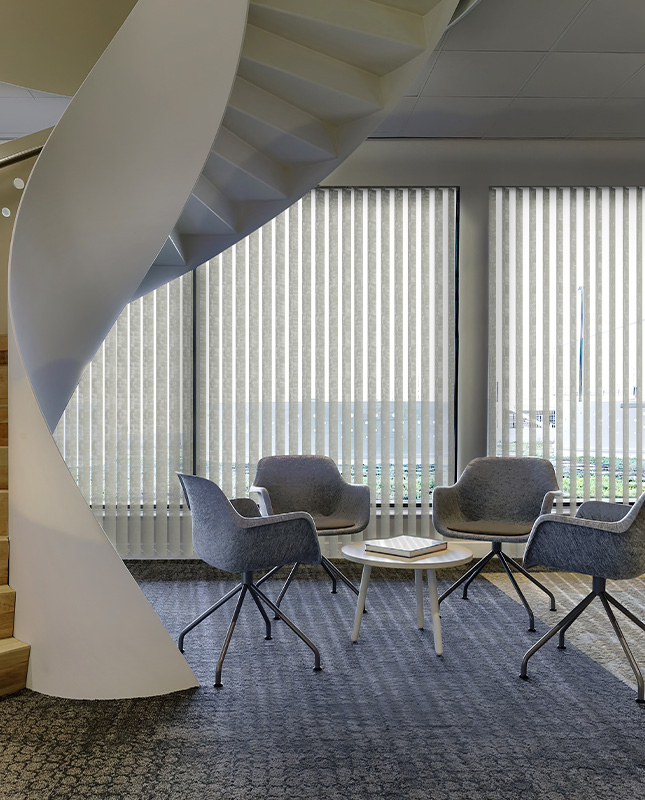 Decorquip light grey vertical blinds in a modern commercial seating area with floor-to-ceiling windows